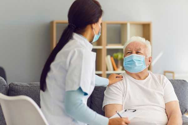 Care Day. Elderly man with carer in nursing home