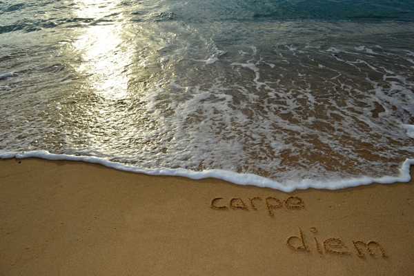 Carpe Diem – Seize the Day. Beach at sunset with the words Carpe Diem written in the sand