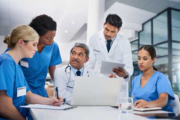 Rare Disease Day. Doctors and nurses talking around a computer