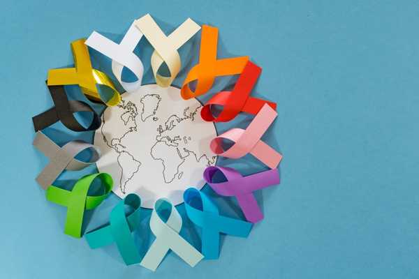 World Cancer Day. Multi-coloured ribbons surrounding a picture of the earth