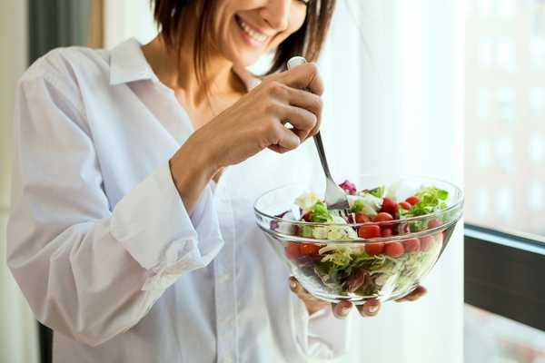 Lady eating a bowl of salad for BNF Healthy Eating Week
