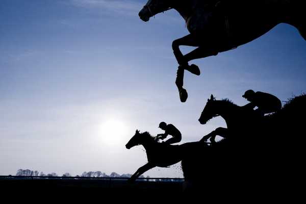 Horses jumping over a fence for Grand National