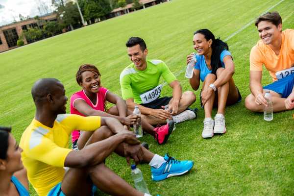 People sitting on grass after a running race for International Day of Sport for Development and Peace