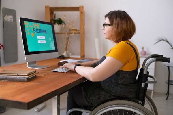 Lady in wheelchair working on a computer for Learning Disability Week