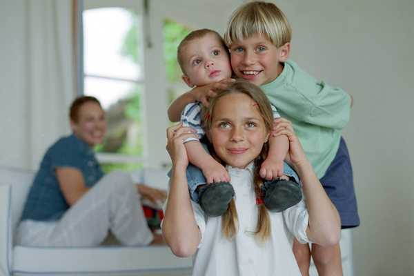 Brothers and sisters climbing on each other for National Siblings Day