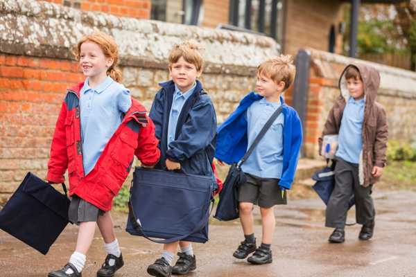 Boys and girls in a line walking to school for Walk to School Week