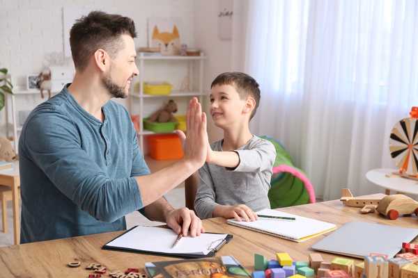 Son and Dad high fiving each other for World Autism Awareness Day