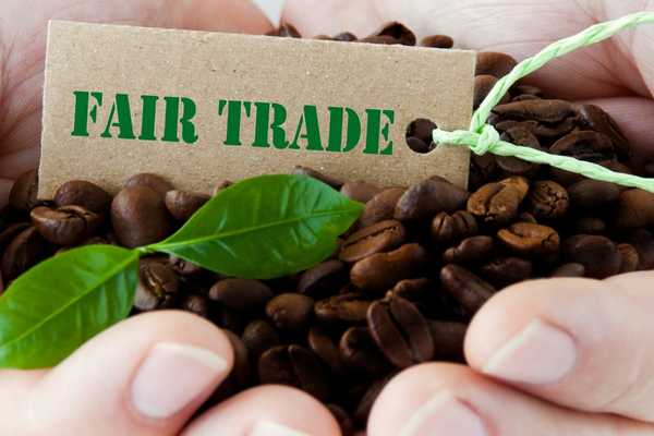 Fair trade sign with coffee in someone's hands for World Fair Trade Day