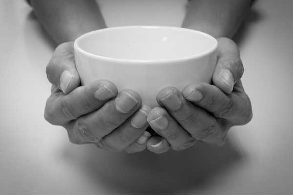 Person holding an empty bowl for World Hunger Day