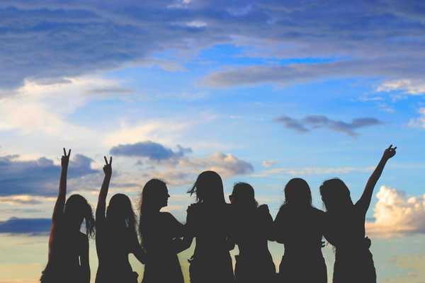 Silhouette of seven women against an early evening sky for International Women's Day