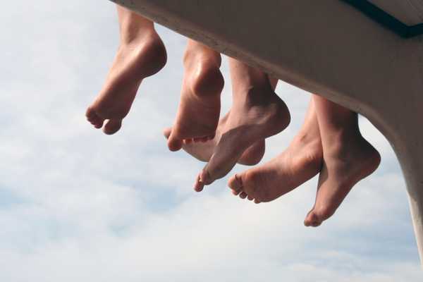 Three pairs of feet dangling in the air for National Feet Week