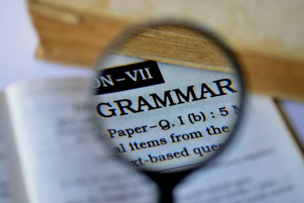 Magnifying glass over the word grammar for National Grammar Day