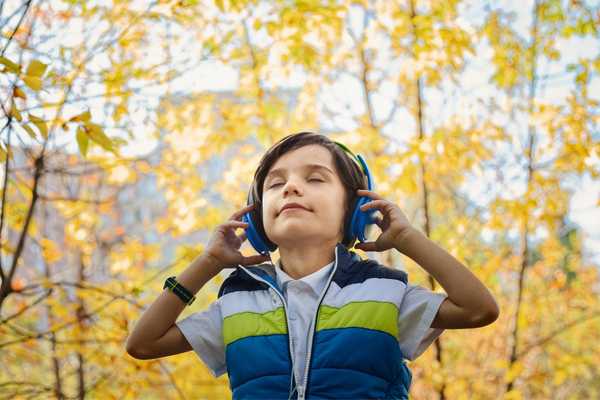 Boy in a park with headphones on for World Hearing Day