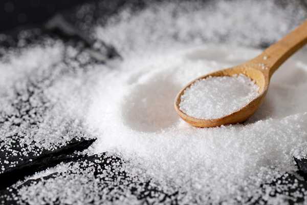 Salt scattered on a work surface with a spoon for World Salt Awareness Week