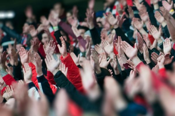 Crowds in a stadium with hands in the air for All-Ireland Senior Football Championship Final