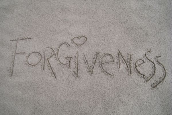 The word forgiveness written in the sand for Global Forgiveness Day