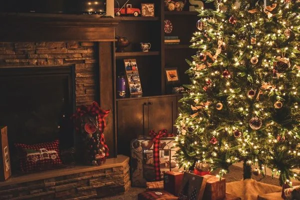 Christmas tree by a fireplace with presents underneath for 100 Days to Christmas