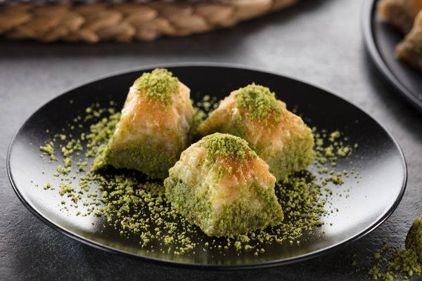 Three pieces of baklava on a black plate for Baklava Day