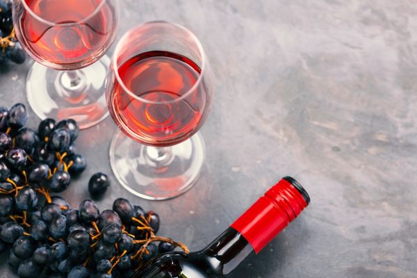 Glass of rose wine with a grapes and bottle head for Beaujolais Nouveau Day