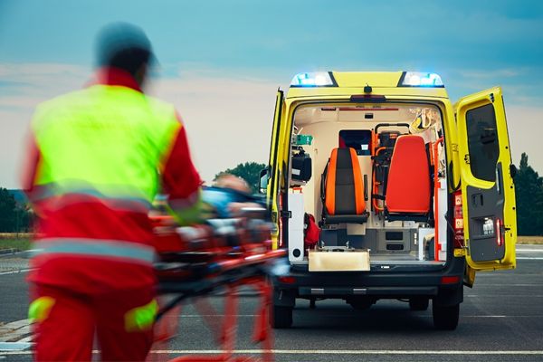 Paramedic bringing a stretcher towards an ambulance for Emergency Services Day 999 Day