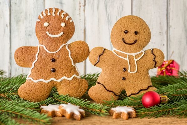 Two smiling gingerbread cookies holding hands for Gingerbread Cookie Day