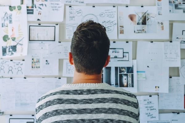 Man looking at a board full of paper notes for Global Entrepreneurship Week