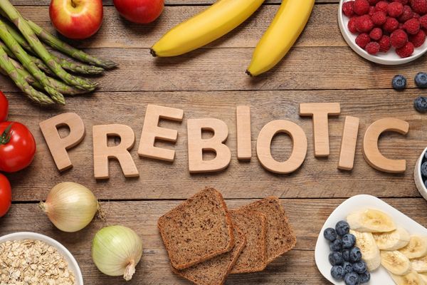 Array of fruit and bread on a wooden table and text reads "Prebiotic" for Global Prebiotics Week