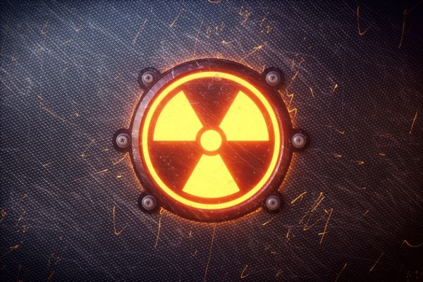 Glowing "nuclear" symbol against a black background for International Day for the Total Elimination of Nuclear Weapons