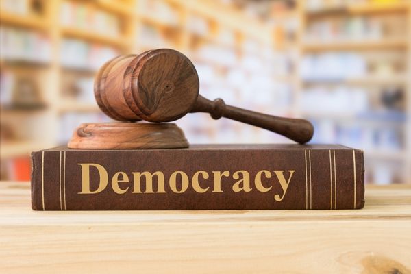 Book entitled "Democracy" with gavel on top for International Day of Democracy