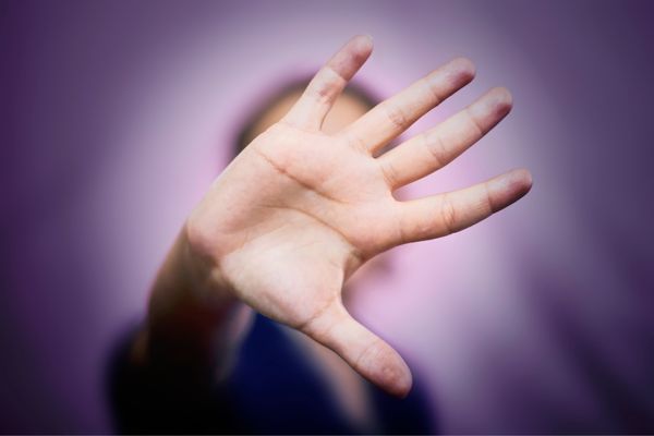 Person pushing their hand against a window for International Day of Non Violence