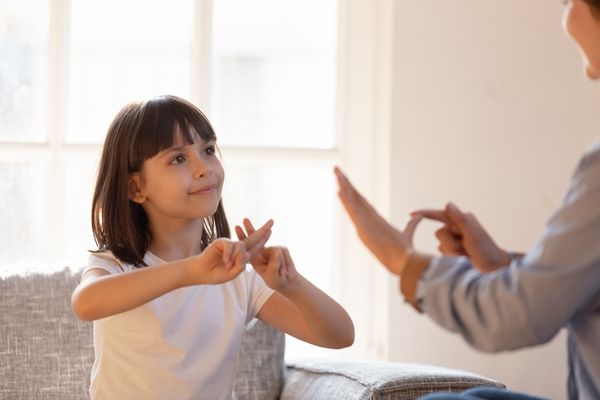 Adult and child communicating through sign language for International Day of Sign Languages