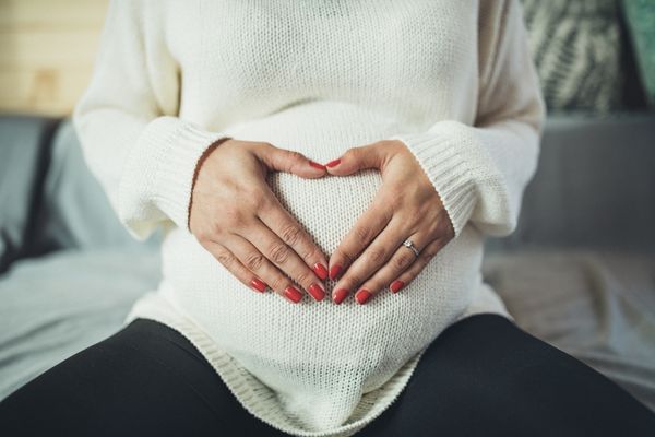 Pregnant person holding their hands in the shape of a heart over their stomach for International Foetal Alcohol Spectrum Disorders Day