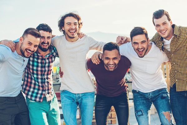 Group of 6 men with their arms around each other for International Men's Day