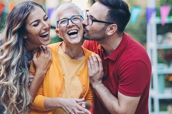 Man and woman kissing a lady on the cheek for Mother In Law Day