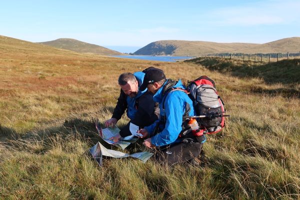 Two men at the top of a mountain looking at a map for Mourne Mountain Marathon