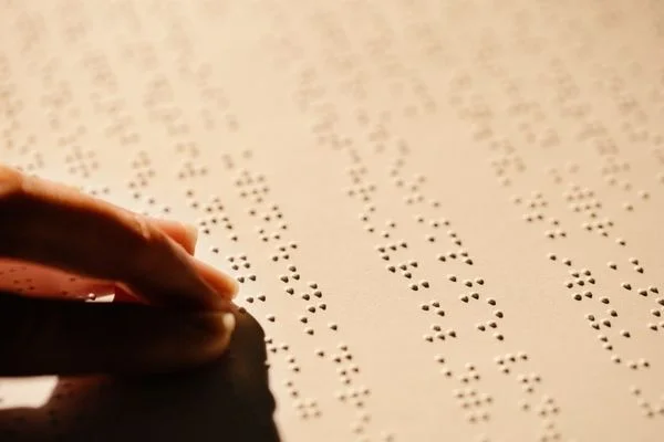 Two fingers reading Braille for National Braille Week