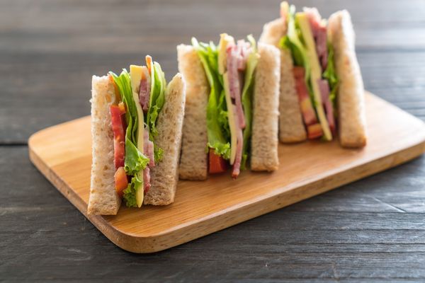 Three sandwiches on a wooden board for National Sandwich Day