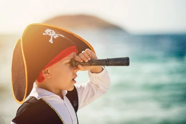 Little boy dressed as a pirate using a telescope for Talk Like A Pirate Day