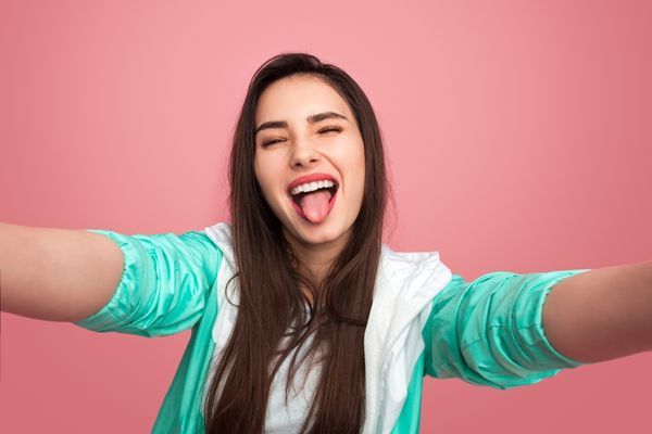 Girl sticking her tongue out at the camera World Tongue Twister Day