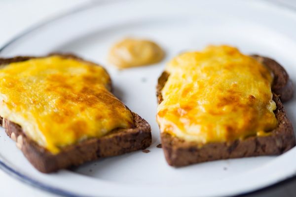 Two slices of rarebit on toast on a white plate for Welsh Rarebit Day