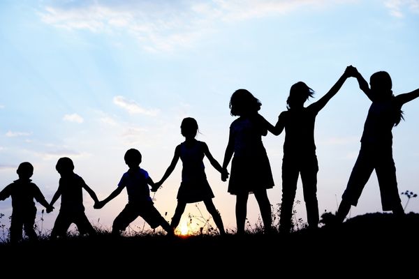 Silhouette of 5 children holding hands for World Children's Day