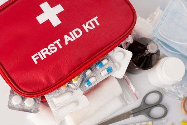 Open first aid kit with scissors, tablets and bandages for World First Aid Day