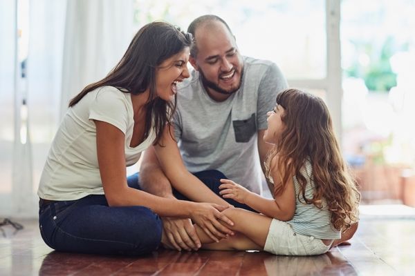 Man and woman - parents laughing with a young child for World Nursery Rhyme Week