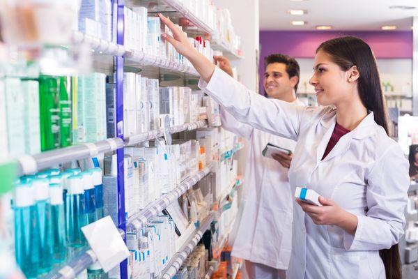 Two pharmacists lifting medicine off a shelf for World Pharmacists Day