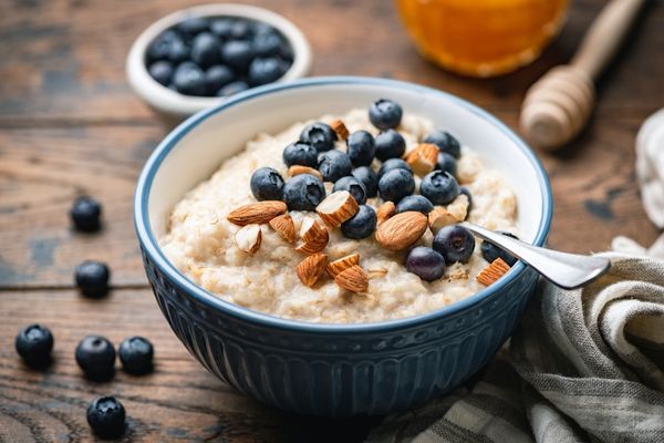 Bowl of porridge with fruit and a silver spoon for World Porridge Day