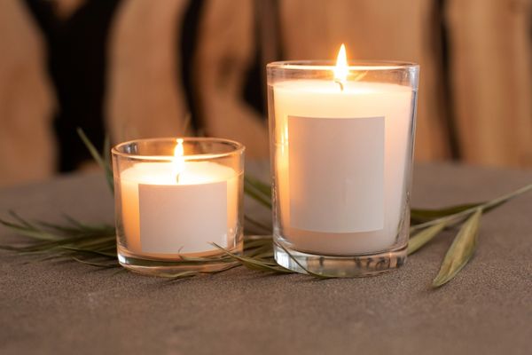 Two lit white candles of different sizes for Candle Day