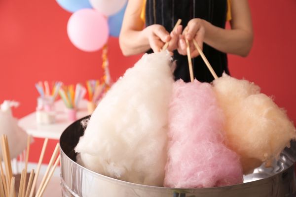 Person holding 3 sticks of candy floss for Candy Floss Day