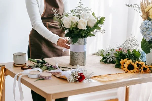 Woman arranging bouquet of flowers for Make a Gift Day