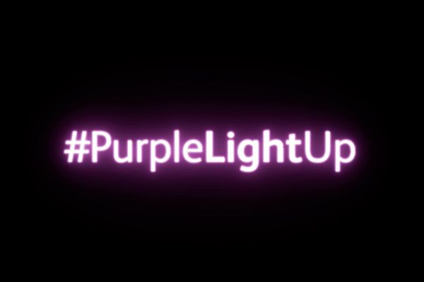 Black background with purple neon text reading "#PurpleLightUp"