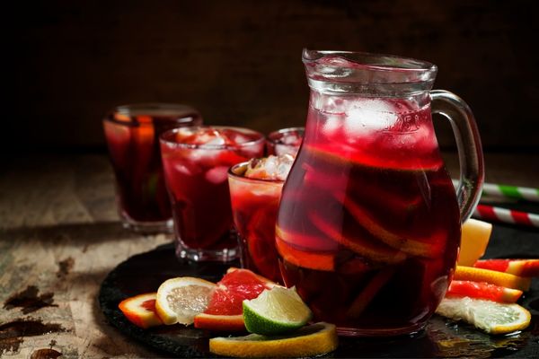 Jug and full glass of sangria with fruit for Sangria Day